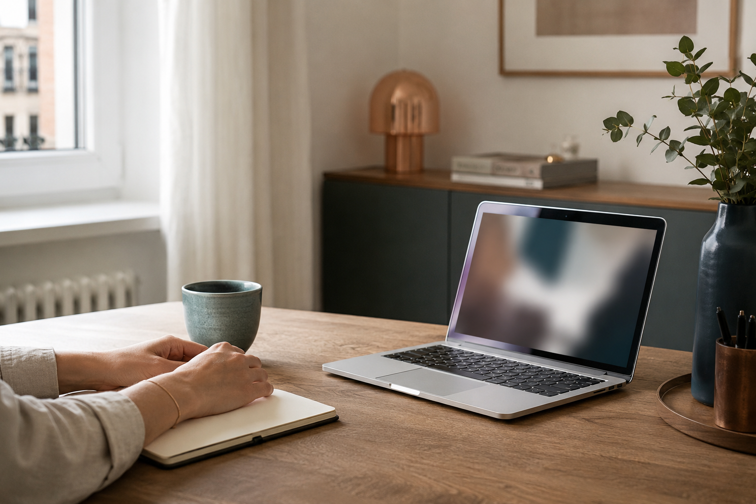 Persoană aflată într-o ședință online, cu jurnal și laptop